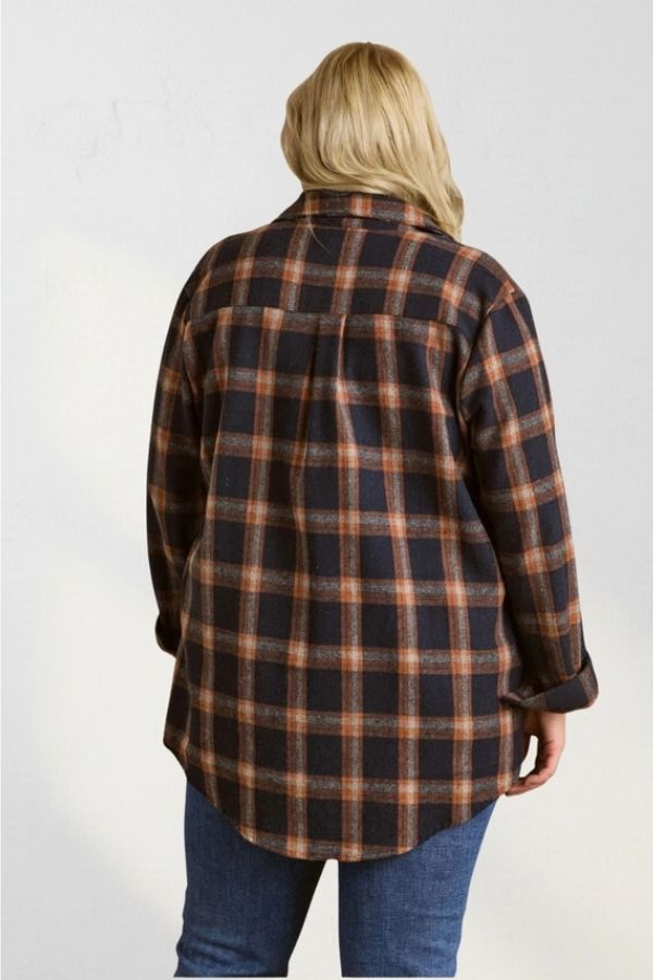 Back view of a person wearing an oversized navy and orange plaid Curvy Plaid Flannel Shirt and blue jeans.