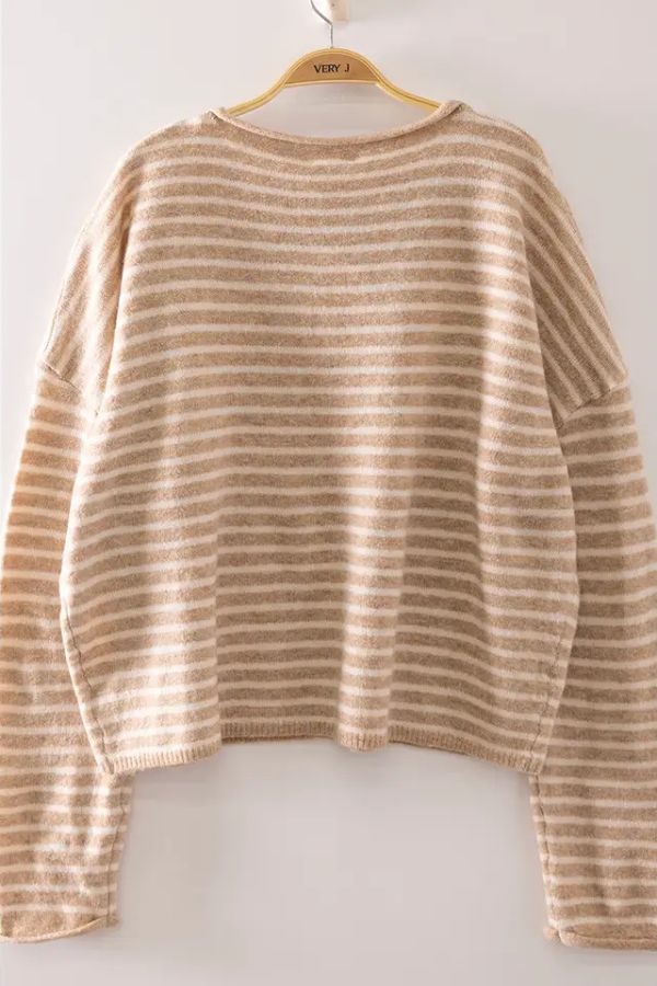 The Striped Button Front Sweater, featuring beige and cream stripes, hangs on a wooden hanger against a plain white wall.