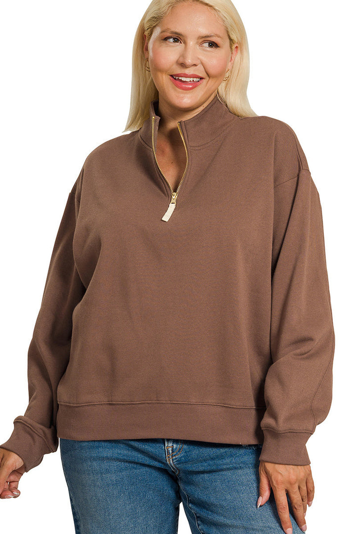 A smiling woman with long blonde hair wears the Plus Half Zip Sweatshirt in a relaxed fit paired with blue jeans, standing against a white background.