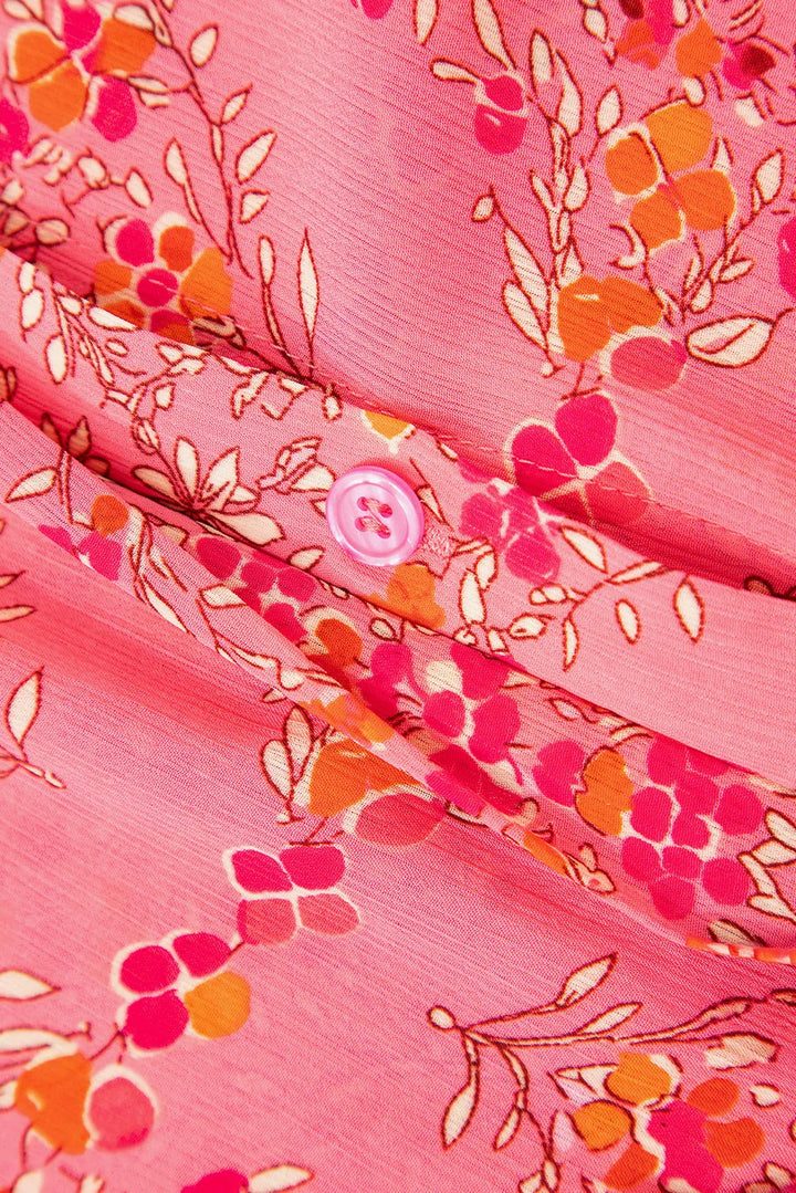 Close-up of the Floral Puff Sleeve Blouse, featuring pink fabric with red, orange, and white flowers, a small pink button, and detailed stitching—a lightweight women's top perfect for any occasion.
