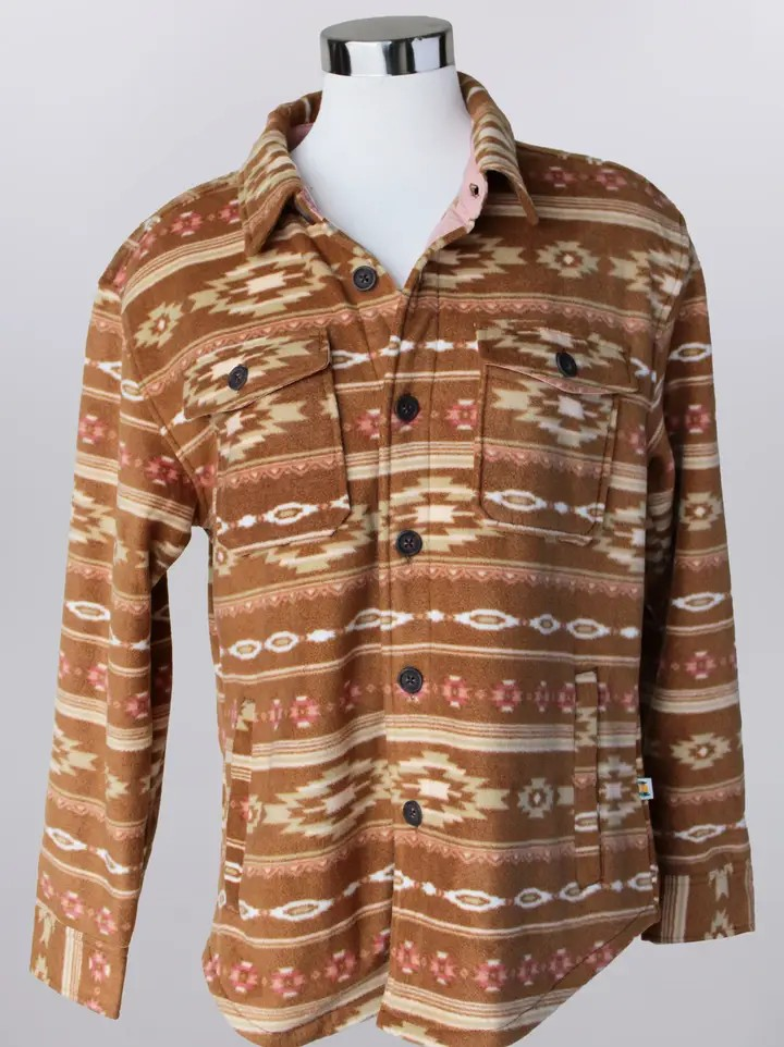 The Southwestern Fleece Shacket is a brown and tan geometric patterned button-up, designed in a classic Southwestern shacket style with two front chest pockets, displayed on a mannequin torso against a plain background.